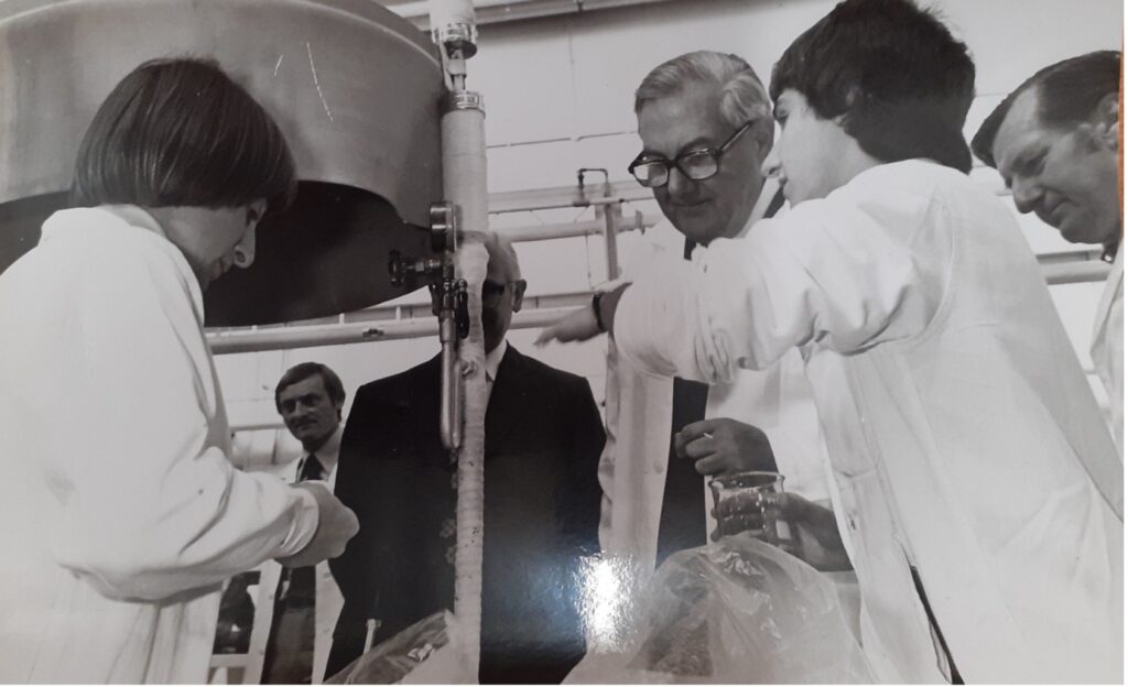 A black-and-white photograph. Food researchers in lab coats developing ice cream sauces.